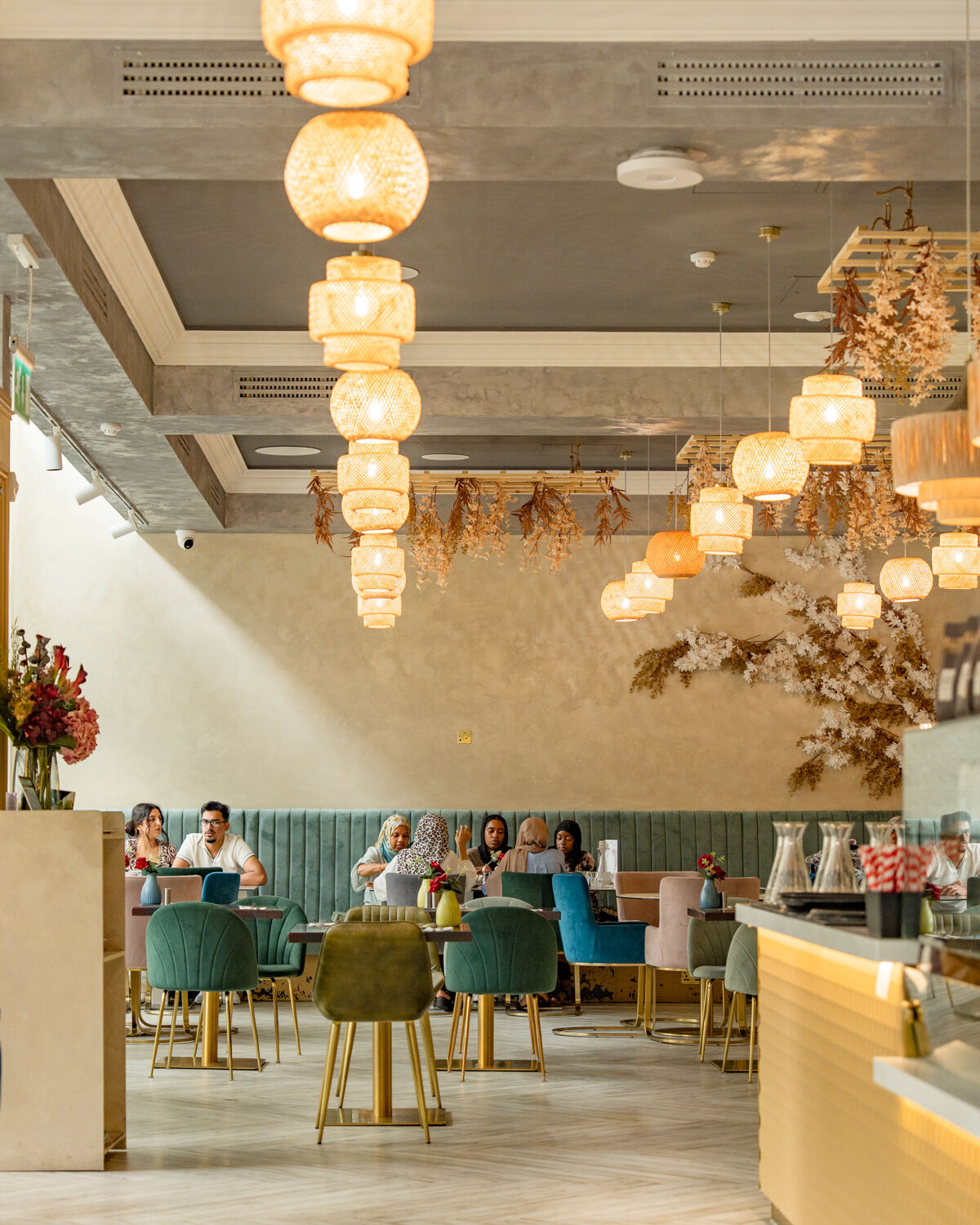 The dining room at Fabrice, warm pendant lighting and green velvet seating