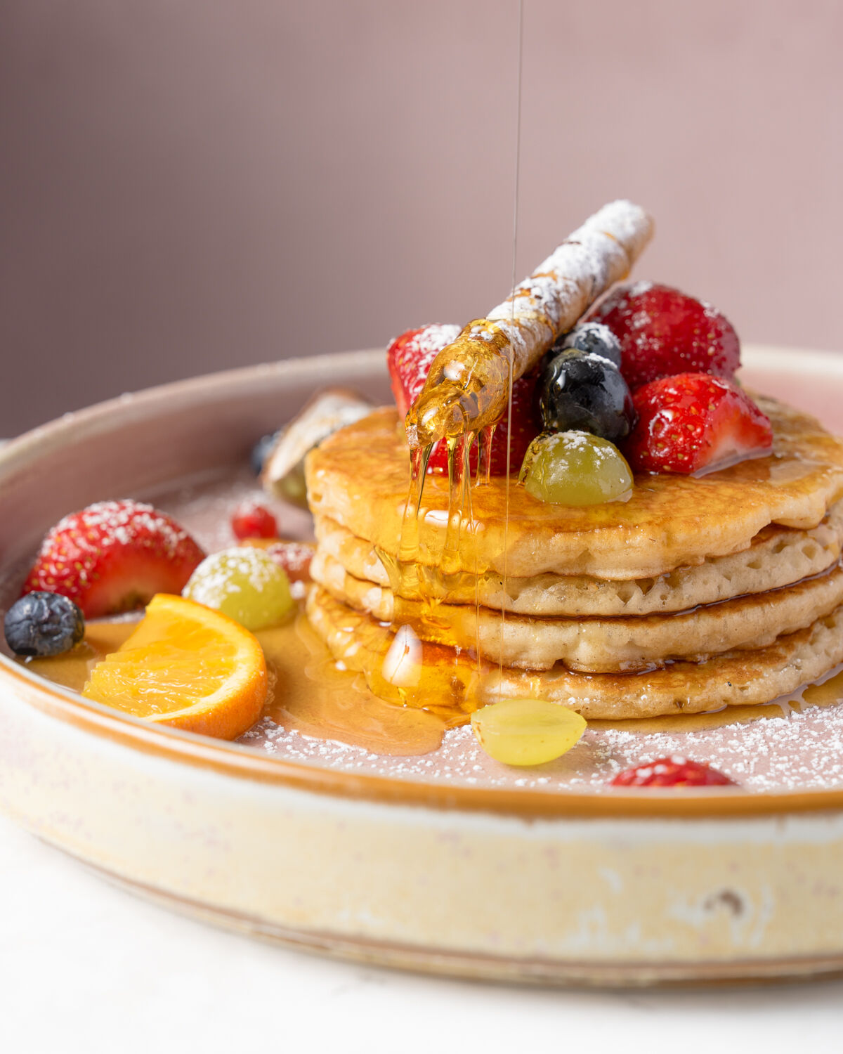 Tall stack of pancakes with fresh fruit